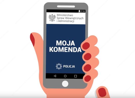 ręka trzymająca telefon komórkowy z wyświetloną aplikacją Moja Komenda